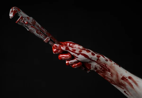 Mano sangrienta sosteniendo una llave ajustable, llave sangrienta, fontanero loco, tema sangriento, tema de Halloween, fondo negro, mano aislada y sangrienta de un asesino, asesino sangriento, psicópata, llave de mono sangrienta — Foto de Stock