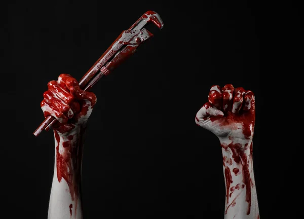 Main sanglante tenant une clé réglable, clé sanglante, plombier fou, thème sanglant, thème d'Halloween, fond noir, main isolée et sanglante d'un assassin, meurtrier sanglant, psychopathe, clé à singe sanglante — Photo