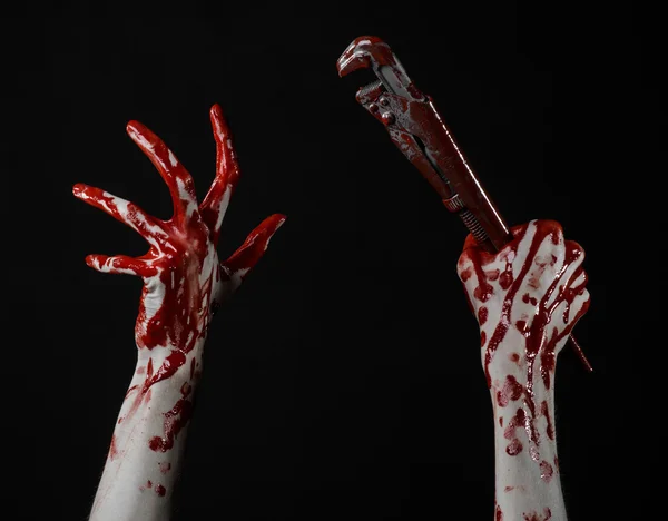 Mano sangrienta sosteniendo una llave ajustable, llave sangrienta, fontanero loco, tema sangriento, tema de Halloween, fondo negro, mano aislada y sangrienta de un asesino, asesino sangriento, psicópata, llave de mono sangrienta — Foto de Stock