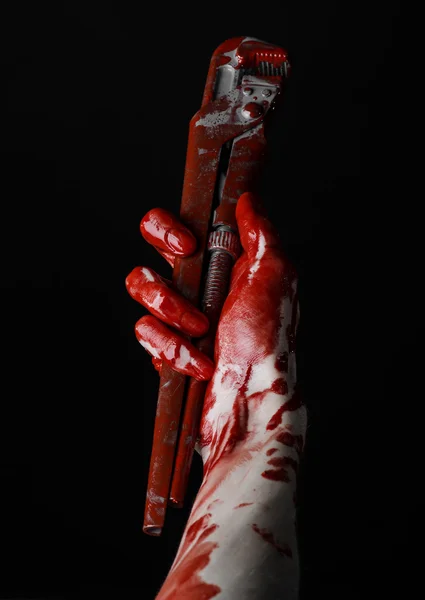 Mano sangrienta sosteniendo una llave ajustable, llave sangrienta, fontanero loco, tema sangriento, tema de Halloween, fondo negro, mano aislada y sangrienta de un asesino, asesino sangriento, psicópata, llave de mono sangrienta — Foto de Stock