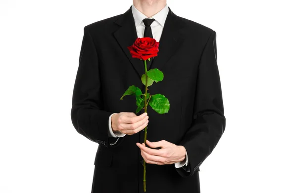 Tema Día de San Valentín y Día de la Mujer: la mano del hombre en un traje con una rosa roja aislada sobre fondo blanco en el estudio —  Fotos de Stock
