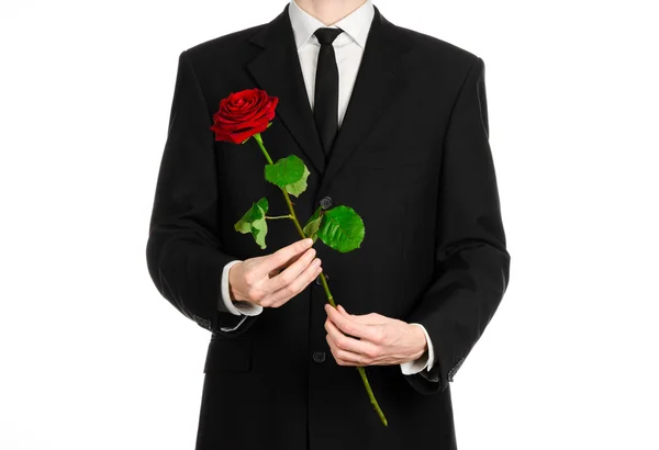 Tema Día de San Valentín y Día de la Mujer: la mano del hombre en un traje con una rosa roja aislada sobre fondo blanco en el estudio — Foto de Stock