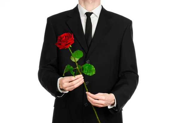 Tema Día de San Valentín y Día de la Mujer: la mano del hombre en un traje con una rosa roja aislada sobre fondo blanco en el estudio —  Fotos de Stock