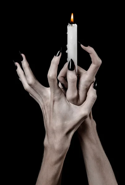 Mains tenant une bougie, une bougie est allumée, fond noir, solitude, chaleur, dans l'obscurité, mains mortes, mains sorcières — Photo