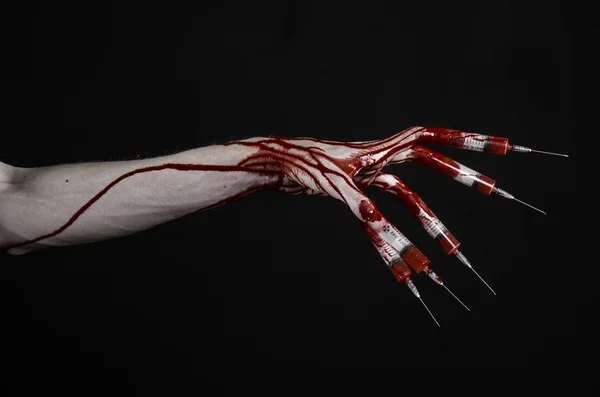 Bloedige hand met spuit op de vingers, tenen spuiten, hand spuiten, verschrikkelijk bloedige hand, halloween thema, zombie arts, zwarte achtergrond, geïsoleerd — Stockfoto