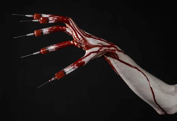 Bloedige hand met spuit op de vingers, tenen spuiten, hand spuiten, verschrikkelijk bloedige hand, halloween thema, zombie arts, zwarte achtergrond, geïsoleerd — Stockfoto