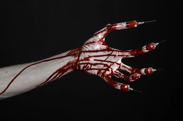 Blodiga hand med spruta på fingrar, tår sprutor, hand sprutor, fruktansvärda blodiga hand, halloween-tema, zombie läkare, svart bakgrund, isolerade — Stockfoto