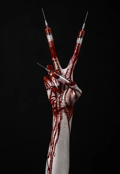 Mano insanguinata con siringa sulle dita, siringhe per dita dei piedi, siringhe a mano, orribile mano insanguinata, tema di Halloween, medico zombie, sfondo nero, isolato — Foto Stock