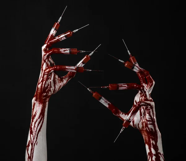 Bloedige hand met spuit op de vingers, tenen spuiten, hand spuiten, verschrikkelijk bloedige hand, halloween thema, zombie arts, zwarte achtergrond, geïsoleerd — Stockfoto