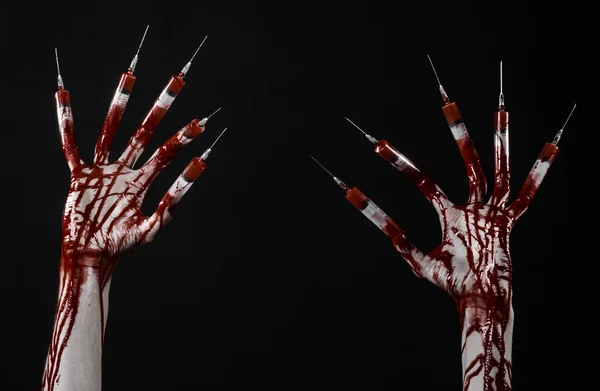 Bloedige hand met spuit op de vingers, tenen spuiten, hand spuiten, verschrikkelijk bloedige hand, halloween thema, zombie arts, zwarte achtergrond, geïsoleerd — Stockfoto