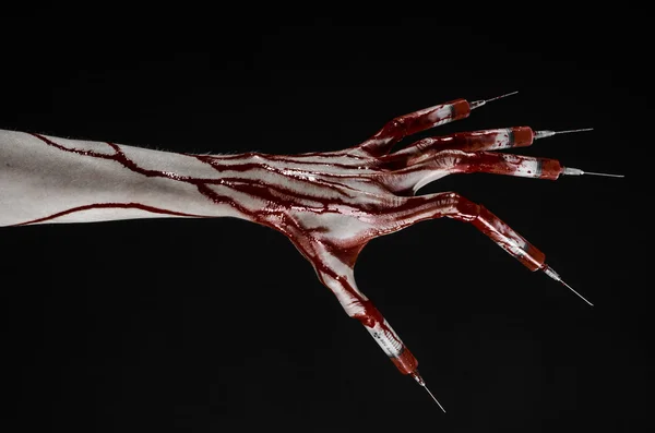 Кровавая рука со шприцем на пальцах, шприцы на пальцах ног, ручные шприцы, ужасная кровавая рука, тема Хэллоуина, доктор-зомби, черный фон, изолированный — стоковое фото