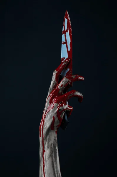 Bloody Halloween theme: zombie killer holding a large bloody knife isolated on black background in studio. — Stock Photo, Image