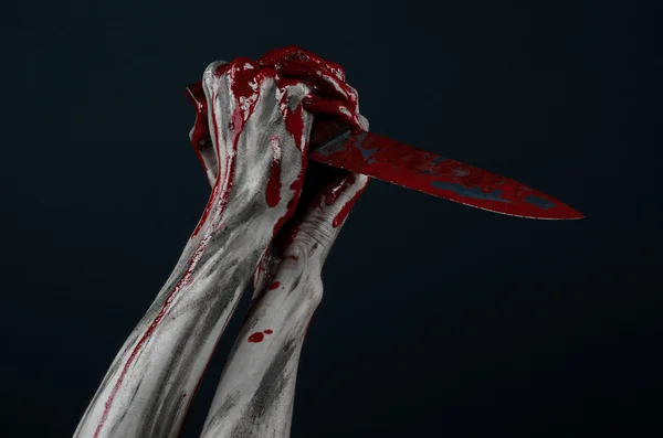Tema de Halloween sangriento: asesino zombi sosteniendo un gran cuchillo ensangrentado aislado sobre fondo negro en el estudio . —  Fotos de Stock