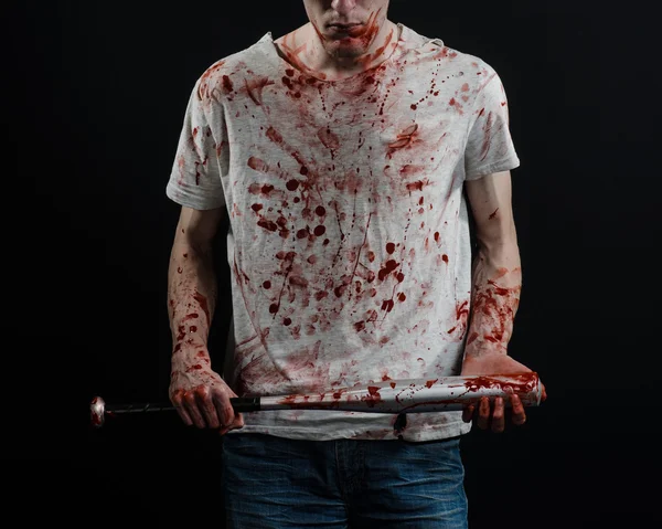 Bloody topic: The guy in a bloody T-shirt holding a bloody bat on a black background — Stock Photo, Image