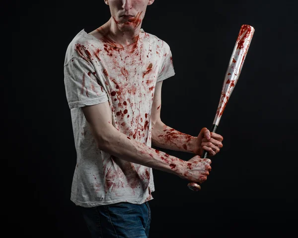 Bloody topic: The guy in a bloody T-shirt holding a bloody bat on a black background — Stock Photo, Image