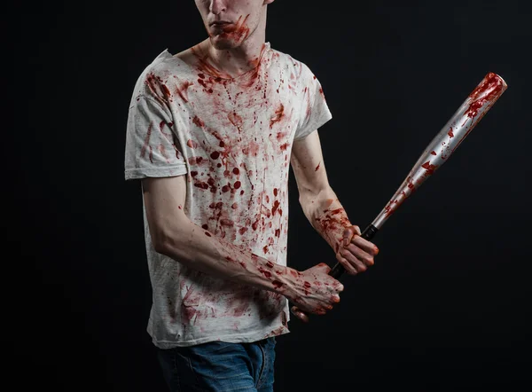Bloedige onderwerp: de man in een bloedige T-shirt een bloedige vleermuis houden op een zwarte achtergrond — Stockfoto
