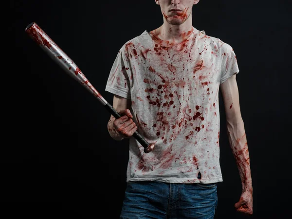 Sujet sanglant : Le gars en t-shirt sanglant tenant une batte sanglante sur un fond noir — Photo