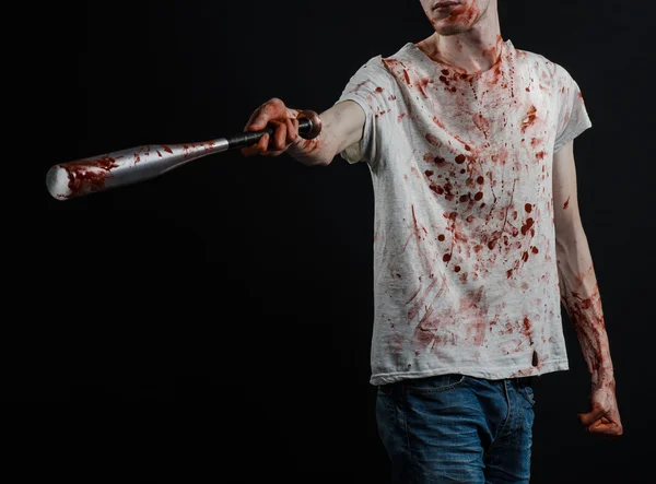 Tema sangriento: El tipo con una camiseta ensangrentada sosteniendo un murciélago ensangrentado sobre un fondo negro — Foto de Stock