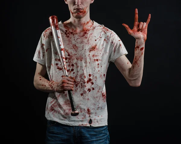 Bloody topic: The guy in a bloody T-shirt holding a bloody bat on a black background — Stock Photo, Image