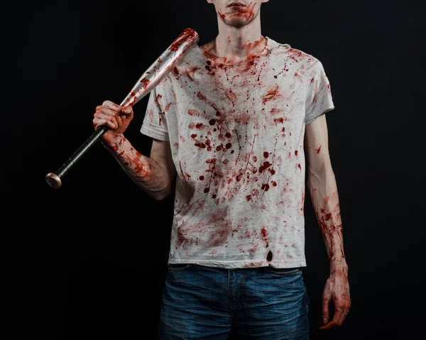 Bloody topic: The guy in a bloody T-shirt holding a bloody bat on a black background — Stock Photo, Image