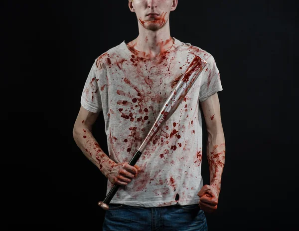 Tema sangriento: El tipo con una camiseta ensangrentada sosteniendo un murciélago ensangrentado sobre un fondo negro —  Fotos de Stock