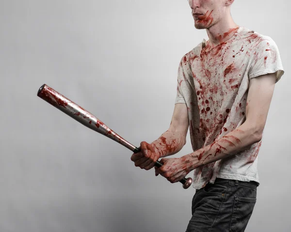 Bloody topic: The guy in a bloody T-shirt holding a bloody bat on a white background — Stock Photo, Image