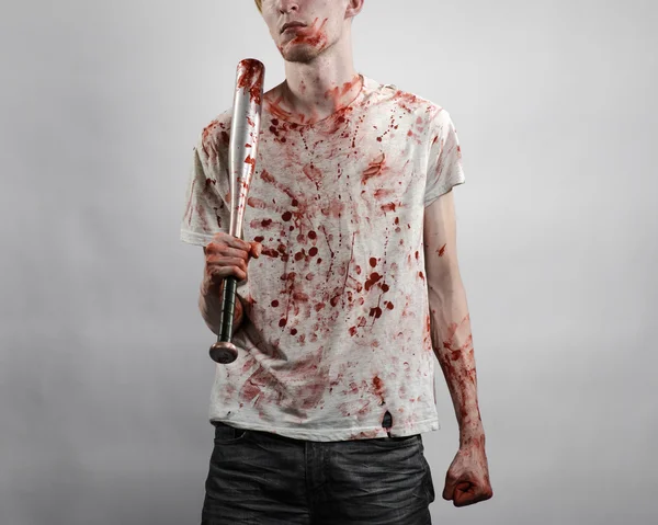 Bloedige onderwerp: de man in een bloedige T-shirt een bloedige vleermuis houden op een witte achtergrond — Stockfoto