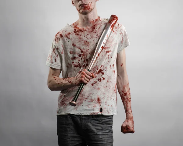 Argomento sanguinoso: Il ragazzo con una maglietta insanguinata con una mazza insanguinata su uno sfondo bianco — Foto Stock