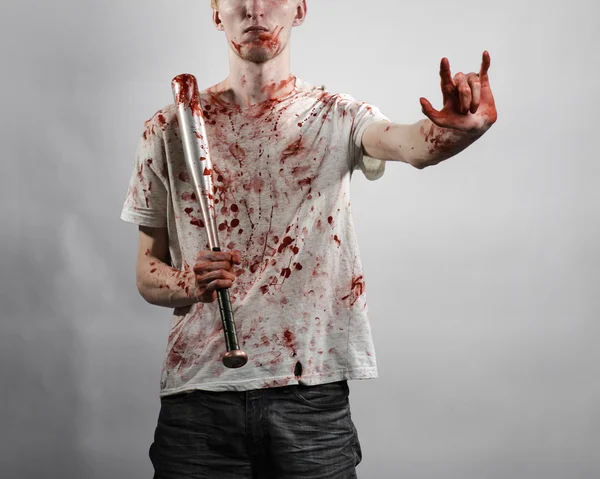 Bloody topic: The guy in a bloody T-shirt holding a bloody bat on a white background — Stock Photo, Image