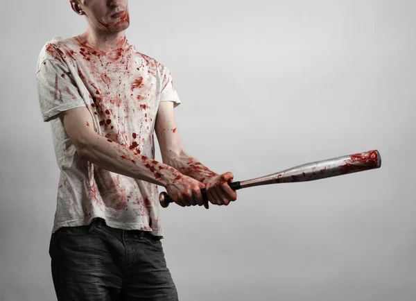 Bloody topic: The guy in a bloody T-shirt holding a bloody bat on a white background — Stock Photo, Image