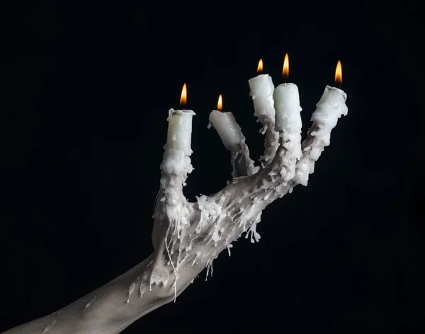 万圣节主题: 手戴着一根蜡烛和滴熔化的蜡在黑色上分离背景 — 图库照片