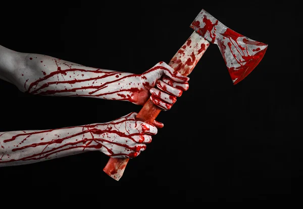 Bloody Halloween theme: bloody hand holding a bloody butcher's ax isolated on black background in studio — Stock Photo, Image