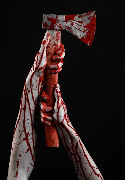 Bloody Halloween theme: bloody hand holding a bloody butcher's ax isolated on black background in studio — Stock Photo, Image