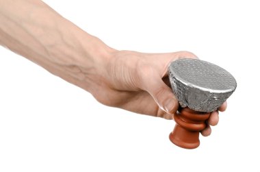 Beyaz bir arka plan üzerinde izole delik bir folyo ile kaplı nargile için tütün ile bir kil kase tutarak barmen