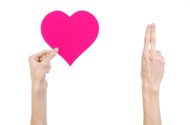 Sevgililer günü ve aşk şarkısı: Studio beyaz bir arka plan üzerinde izole bir pembe kalp tutan el