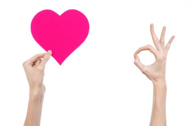 Sevgililer günü ve aşk şarkısı: Studio beyaz bir arka plan üzerinde izole bir pembe kalp tutan el