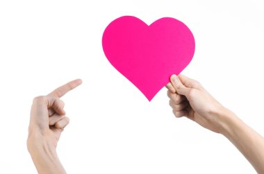 Sevgililer günü ve aşk şarkısı: Studio beyaz bir arka plan üzerinde izole bir pembe kalp tutan el