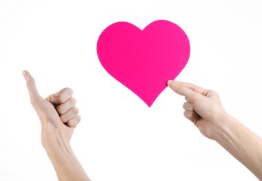 Sevgililer günü ve aşk şarkısı: Studio beyaz bir arka plan üzerinde izole bir pembe kalp tutan el