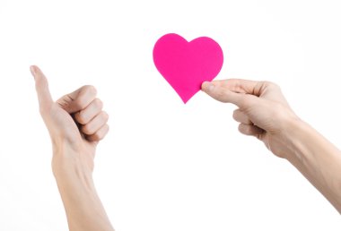 Sevgililer günü ve aşk şarkısı: Studio beyaz bir arka plan üzerinde izole bir pembe kalp tutan el