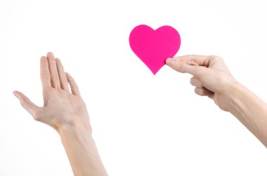 Sevgililer günü ve aşk şarkısı: Studio beyaz bir arka plan üzerinde izole bir pembe kalp tutan el