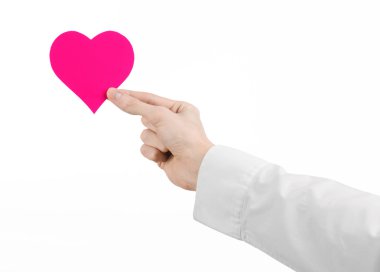 Kalp hastalığı ve sağlık Konu: beyaz bir gömlek beyaz bir arka planda Studio izole bir pembe kalp şeklinde bir kart tutan el doktor