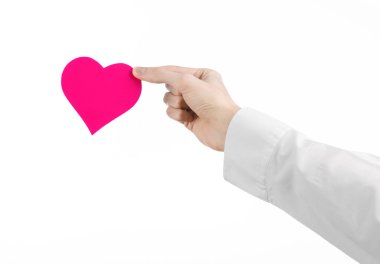 Kalp hastalığı ve sağlık Konu: beyaz bir gömlek beyaz bir arka planda Studio izole bir pembe kalp şeklinde bir kart tutan el doktor