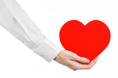 Kalp hastalığı ve sağlık Konu: beyaz bir gömlek beyaz bir arka planda Studio izole kırmızı bir kalp şeklinde bir kart tutan el doktor