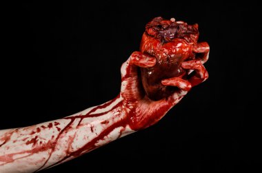 Kan ve Halloween Tema: kanlı kadar kötü bir elle insan kalbi Studio siyah arka plan üzerine izole kanama yırtık tutun