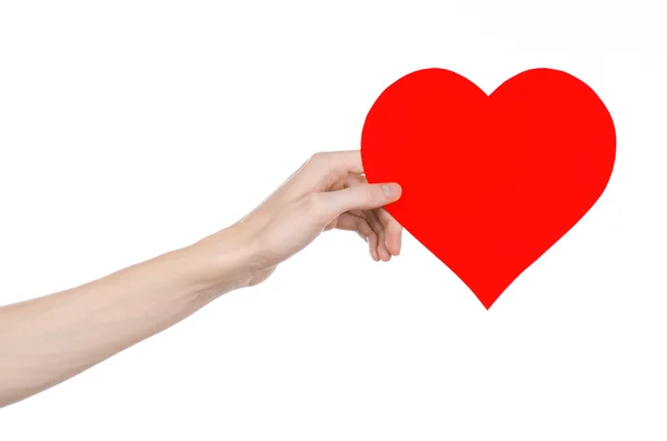 Ημέρα του Αγίου Βαλεντίνου και η αγάπη θέμα: χέρι που κρατά μια κόκκινη καρδιά απομονωθεί σε λευκό φόντο σε στούντιο — Φωτογραφία Αρχείου