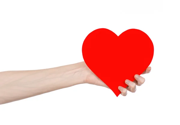День святого Валентина и тема любви: рука держа красное сердце изолированы на белом фоне в студии — стоковое фото