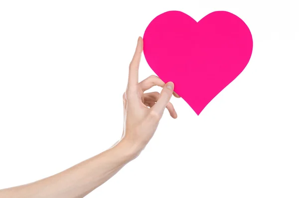 バレンタインデーと愛のテーマ: studio で白い背景に分離されたピンクのハートを持っている手 — ストック写真