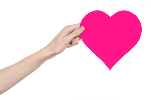 Tema Día de San Valentín y amor: la mano sosteniendo un corazón rosa aislado sobre un fondo blanco en el estudio — Foto de Stock