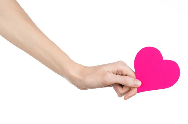 Valentine's Day and love theme: hand holding a pink heart isolated on a white background in studio — Stock Photo, Image