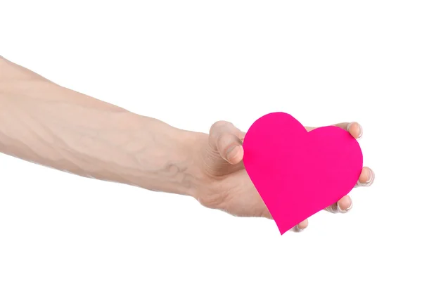 San Valentino e il tema dell'amore: mano che tiene un cuore rosa isolato su sfondo bianco in studio — Foto Stock